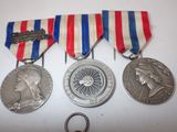 three medals and a keychain are sitting on a table