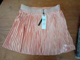 a pink pleated skirt with a tag on it