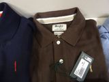 three men ' s polo shirts are lined up on a table