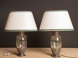 une paire de lampes vertes et blanches posées sur une table, sur fond noir