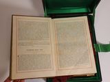 someone is holding an open book in a green case