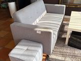 un canapé et un pouf dans un salon avec une table basse
