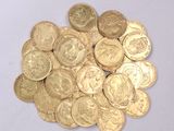 a pile of gold coins sitting on a white surface