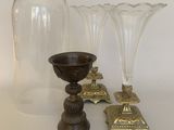 three glass vases and a candle holder on a table