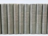 six vieux livres alignés sur une surface blanche
