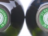 two bottles of wine sitting next to each other on a table