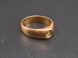 a close up of a gold ring on a black surface