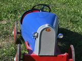 a small toy car sitting in the grass on the side of the road