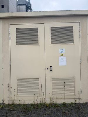 deux portes situées sur le côté d'un immeuble, à côté d'une borne d'incendie