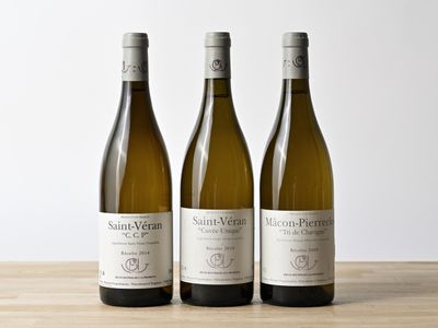 trois bouteilles de vin posées sur une table en bois