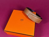 an orange box with a belt on top of it on a pink surface