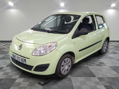 une photo d'une petite voiture verte garée sur un sol à damier
