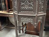 une armoire d'angle ancienne en bois, ornée de sculptures élaborées sur les côtés