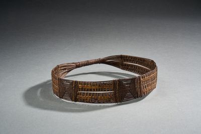 bracelet tissé marron orné de perles marron sur un fond blanc