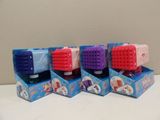 quatre brosses à dents de couleurs différentes dans une boîte posée sur une table