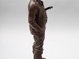 bronze statue of a man with a guitar on a white background