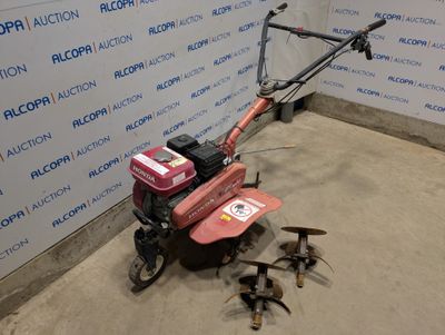 une petite tondeuse à gazon posée par terre devant un mur