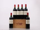 six bottles of red wine in a wooden crate on a table