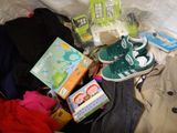 a pile of children ' s clothing and books on a bed