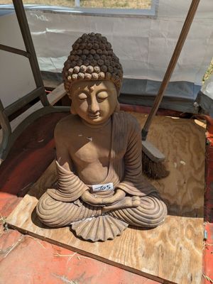 une statue représentant une personne assise en position du lotus