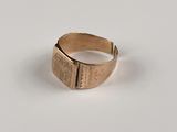 gros plan d'une bague en or sur une surface blanche