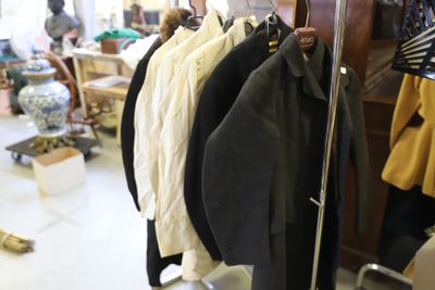 a lot of coats hanging on a rack in a room