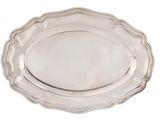 a silver plate with a scalloped edge on a white background