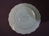 a white plate on a table with a purple cloth