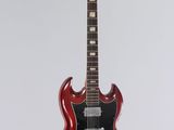 an electric guitar hanging from a rope on a white wall