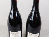 two bottles of wine sitting on top of a table next to each other