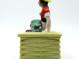 a small figurine of a woman sitting on a bench