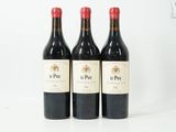 trois bouteilles de vin rouge posées sur une table blanche