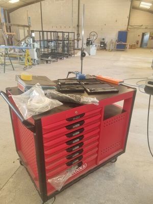un chariot rouge sur lequel sont posés de nombreux outils