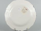underside view of a white plate on a stand on a gray surface
