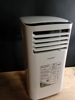 un climatiseur blanc posé sur une table en bois