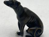 a small statue of a dog that is sitting on the ground