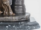 a statue of a woman holding a vase on top of a table