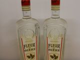 two bottles of liquor sitting on top of a wooden table