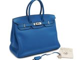 a blue leather handbag with a key in it