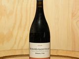 une bouteille de vin posée sur un tonneau en bois
