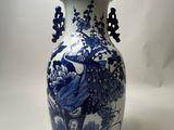 a blue and white vase sitting on a white surface