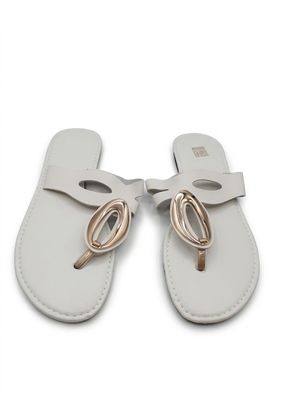 une paire de sandales en cuir blanc ornées d'un nœud doré sur la pointe