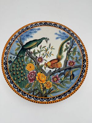 une assiette décorative ornée d'un oiseau et de fleurs