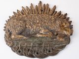a bronze sculpture of a dog laying on top of a table