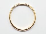 gros plan d'une bague en or sur une surface blanche