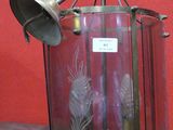 une lanterne en verre surmontée d'une cloche en métal