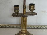 a gold candle holder with two candles on top of it