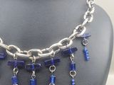 a necklace with blue beads hanging from it on a mannequin