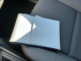 un ordinateur portable posé sur un livre, sur un siège de voiture