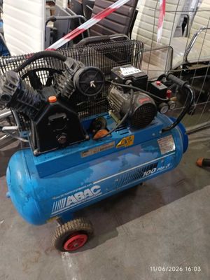 a blue air compressor sitting on a cart in a garage